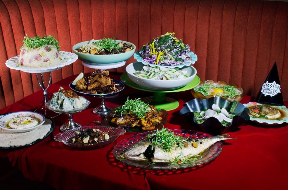Il cibo proposto da Mission Chinese su piatti da portata e palcoscenico con tenda rossa