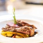 Trattorie a Bolzano e dintorni: Un piatto di carne arrosto con patate e ramo di erba aromatica