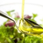 Corso tecnico di frantoio: cucchiaio con olio extravergine di oliva su piatto di insalata