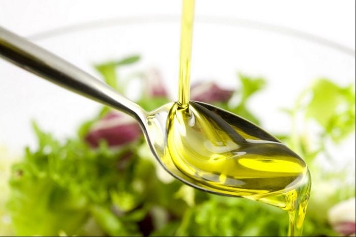 Corso tecnico di frantoio: cucchiaio con olio extravergine di oliva su piatto di insalata