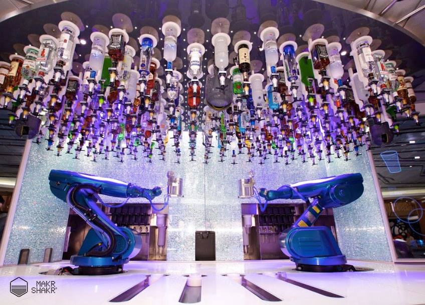 Due robot bartender e il bar robotico Makr Shakr, con le bottiglie sul soffitto