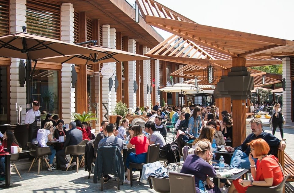 Lo spazio all'aperto con i tavoli gremiti di persone nella corte del centro commerciale Kalaja e Tiranes