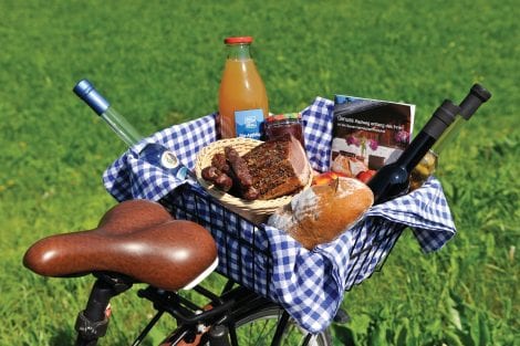 Un cestino della bici pieno di prodotti da mangiare, su un prato