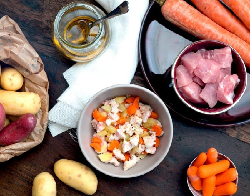 Ingredienti per la preparazione di cibo per cani: carote, carne di vitello, patate, olio di semi 