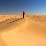 Le dune del deserto tunisino, con un uomo a piedi