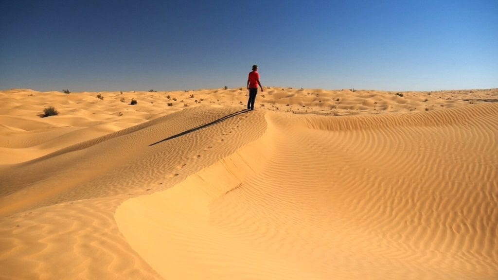 Le dune del deserto tunisino, con un uomo a piedi