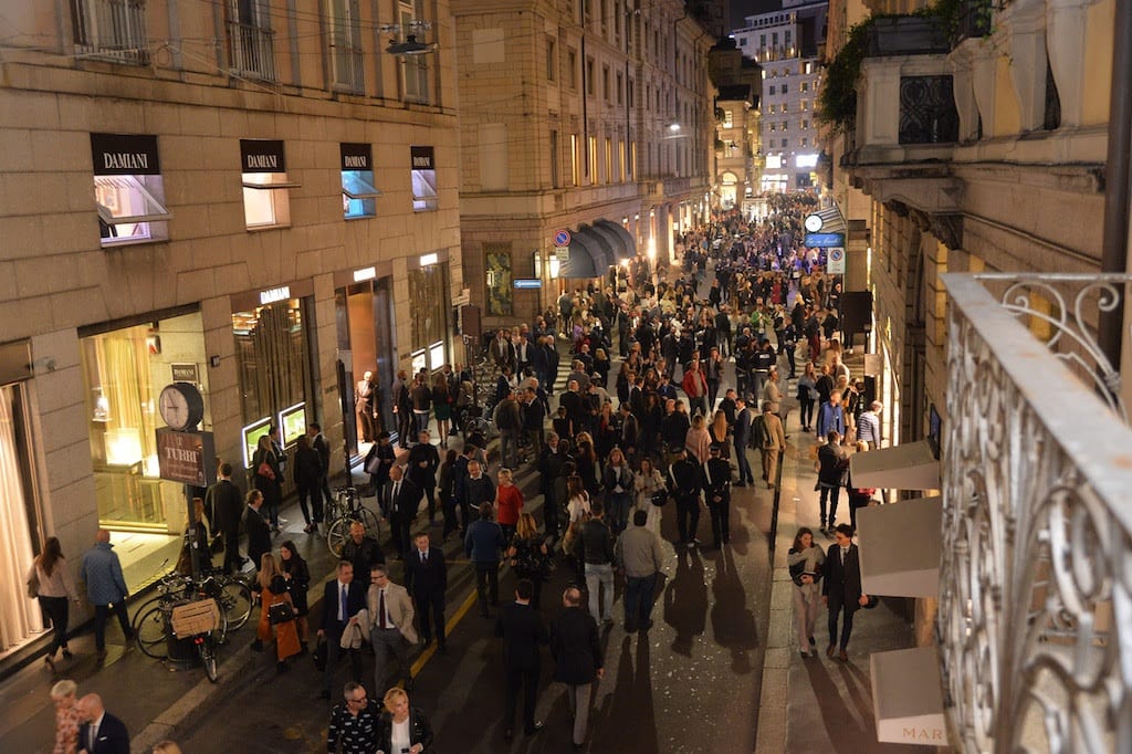 Via Montenapoleone a Milano di sera affollata di persone