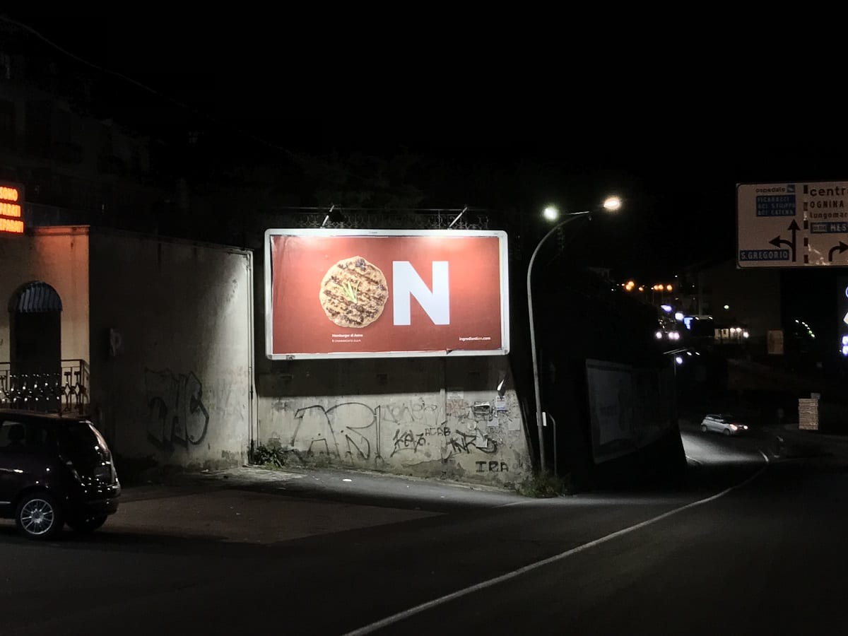 Un cartellone pubblicitario di Fud On per le strade di Catania, di notte