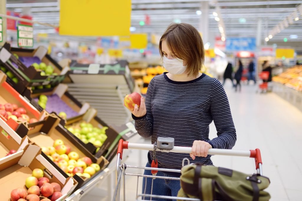 Donna con mascherina al supermercato