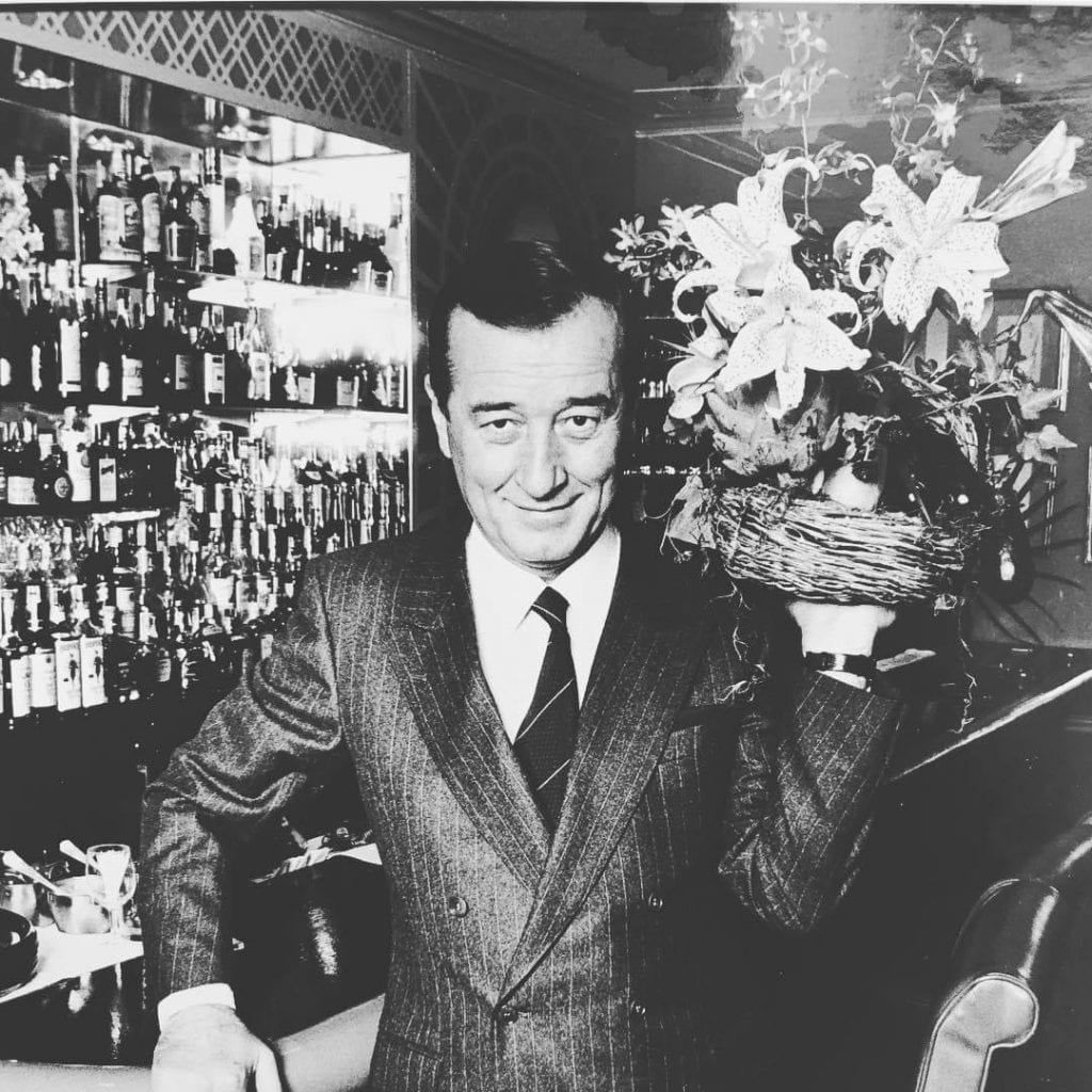 foto in bianco e nero di Sirio Maccioni al banco del bar