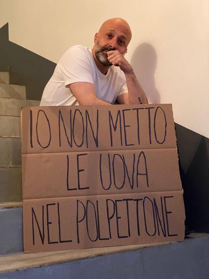 Niko Romito seduto sulle scale con cartello