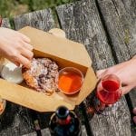 Pollo fritto e vino su tavolo in legno in giardino