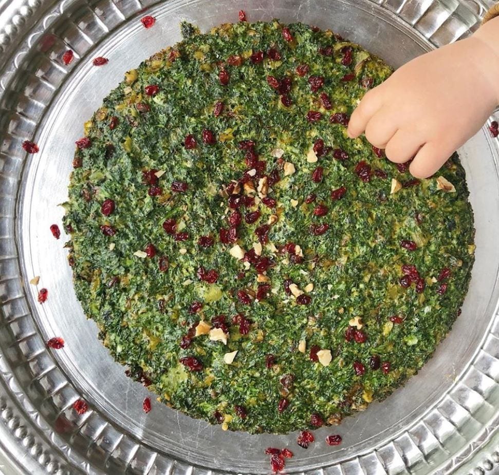 spezie ed erbe per frittata iraniana con mano di bimbo