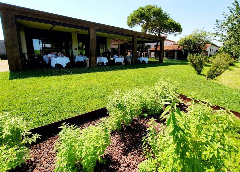 Venissa a Mazzorbo, il giardino delle piante aromatiche e sullo sfondo la sala del ristorante. A destra sotto la tettoia la sala dell'osteria