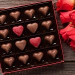 scatola di cioccolatini a cuore e rose rosse