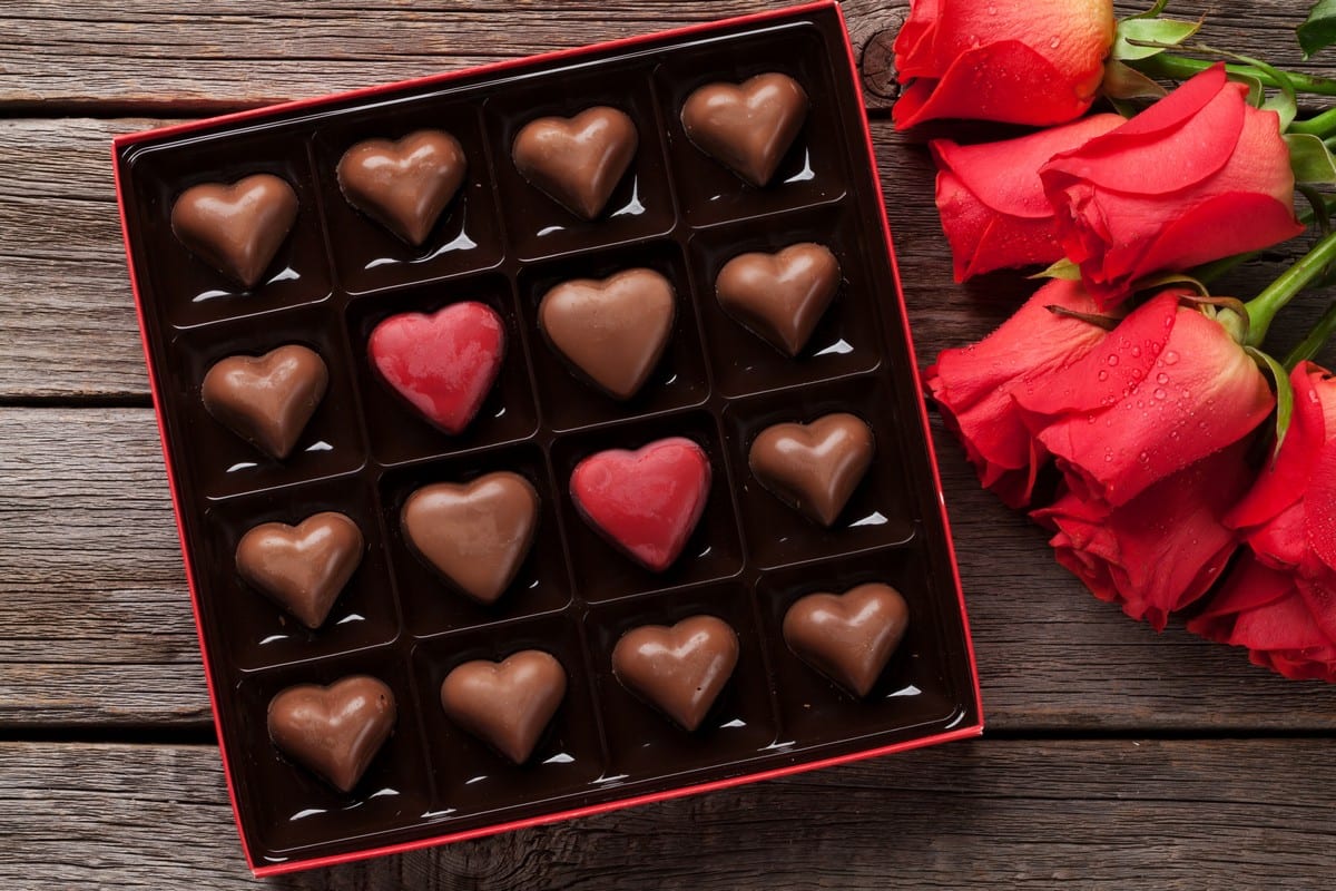 scatola di cioccolatini a cuore e rose rosse