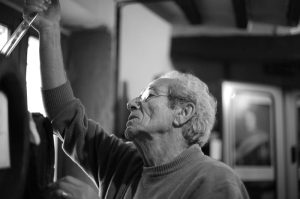Adriano Grosoli in acetaia mentre controlla una botte. Foto in bianco e nero||Foto di gruppo in acetaia per i 90 anni di Adriano Grosoli