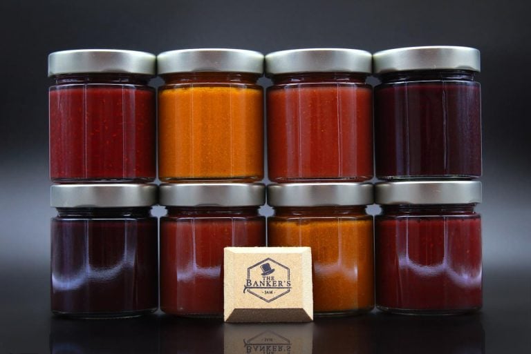 i vasetti di marmellate The Banker's Jam|Campo di fragole|fragole appena raccolte in cassetta|Campo di mirtilli|Un barattolo di marmellata di fragole in confezione regalo