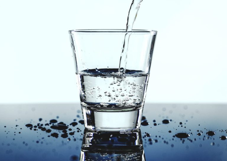 Bicchiere di acqua friante mentre viene riempito|in primo piano bicchiere di acqua blk