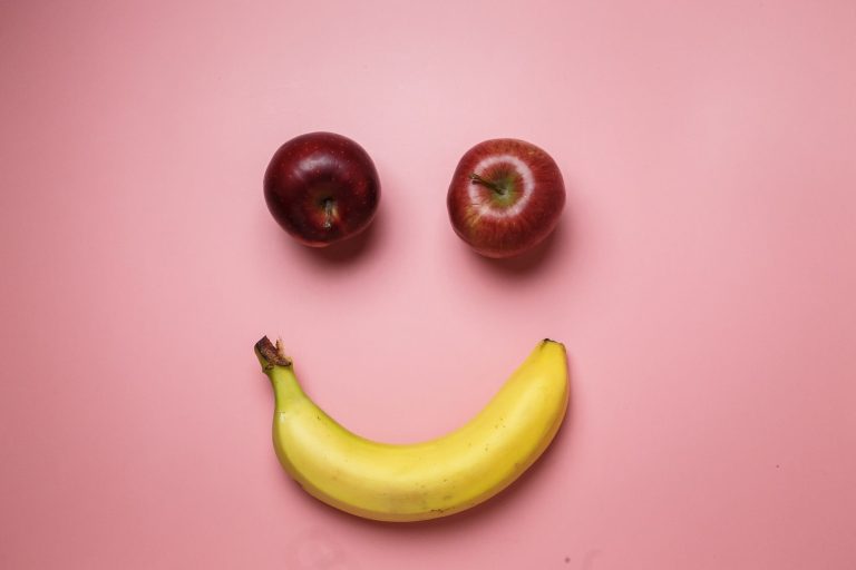 Una banana e due mele che formano un sorriso