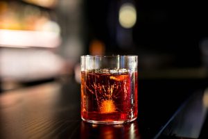 Un Negroni da Drink Kong a Roma|Il main bar di Drink Kong|Salvatore The Maestro Calabrese dietro al bancone del bar|La parete con bottiglie di mezcal e tequila a La Punta di Roma|Il team del Jerry Thomas di Roma