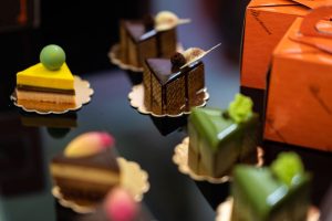 Sweety of Milano & Chocolate: fette di torta su tavolo nero|Macarons|Pasticcere di Cast Alimenti che fa lezione ai bambini|Dolcetti al cioccolato scuro e bianco