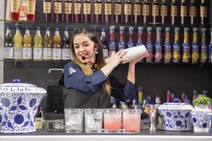 Una barlady shakera un cocktail dietro al bancone di Lady Amarena|Un cocktail all'amarena in coppa Martini||