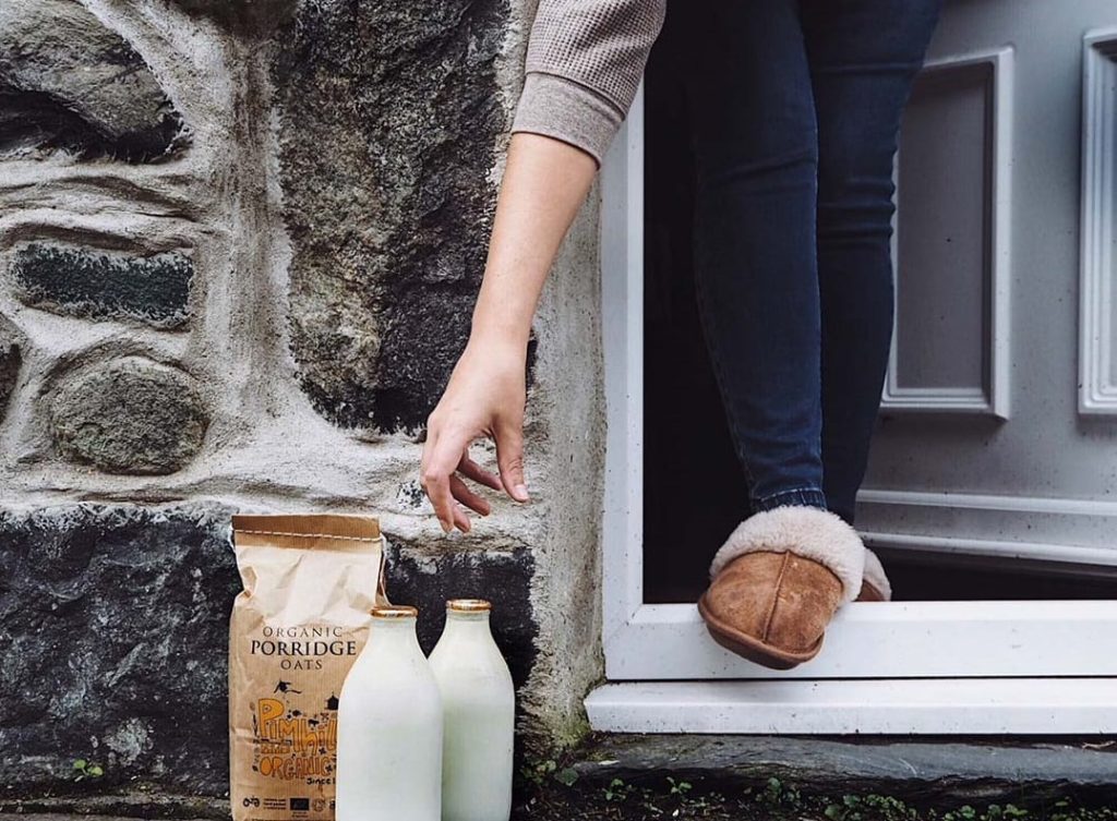 Bottiglie di latte consegnate fuori dalla porta|Due milkmen|Ritiro delle bottiglie di latte vuote|Consegna del latte porta a porta