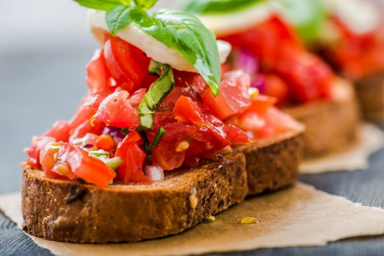 Fetta di pane bruscato con pomodotoro in pezzi e foglia di basilico|Pane e pomodoro - friselle con il pomodoro|Pomodori Così Com'è