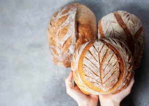 Sourdough bread. Freshly baked organic wheat bread. Child holding fresh round bread. Selective focus