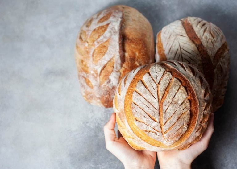 Sourdough bread. Freshly baked organic wheat bread. Child holding fresh round bread. Selective focus