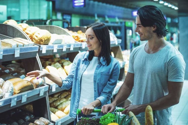 Beautiful young couple leaning on a shopping cart