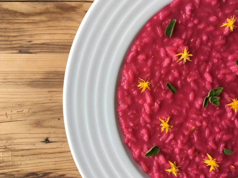 Un piatto di risotto alla rapa rossa su tavolo in legno