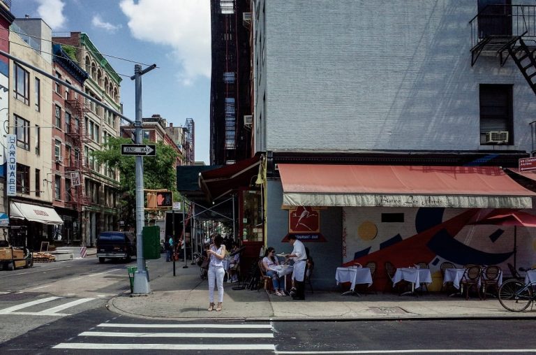 I tavoli su strada di un ristorante all'incrocio tra due strade di New York