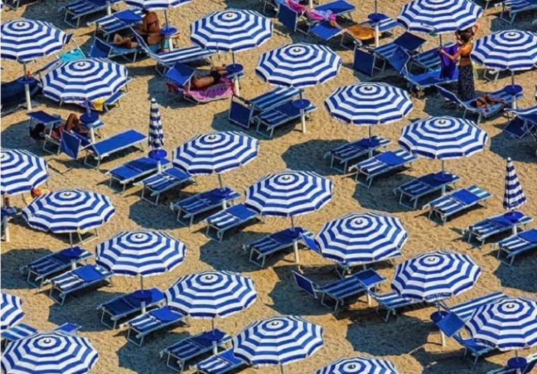 Ombrelloni bianchi e blu aperti in spiaggia