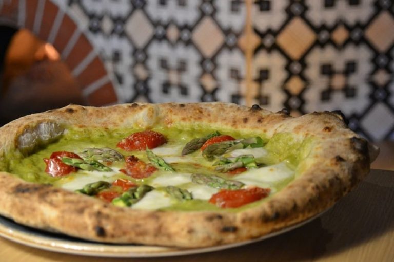 santarpia pizza pizza asparagi e|michele leo da mozzabella davanti al bancone delle pizze in tegia|michele leo davanti a un forno|michele leo condisce una pizza prima di infornarla|santarpa pizza|santarpia pizza capricciosa