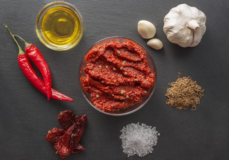 Ciotolina di harissa e ingredienti per prepararla|Funghi reishi su tronco con muschio|Bottiglie di kombucha in vetro