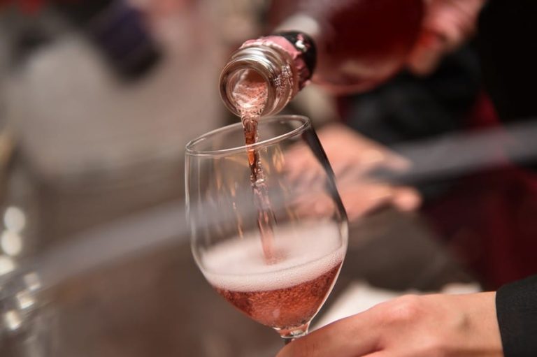 Lambrusco versato in calice dalla bottiglia|