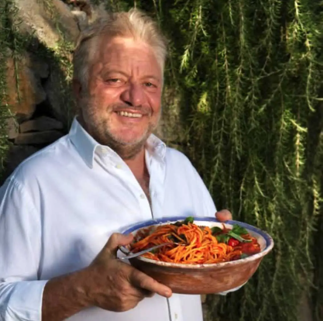Peppe Guida che regge un piatto di spaghetti