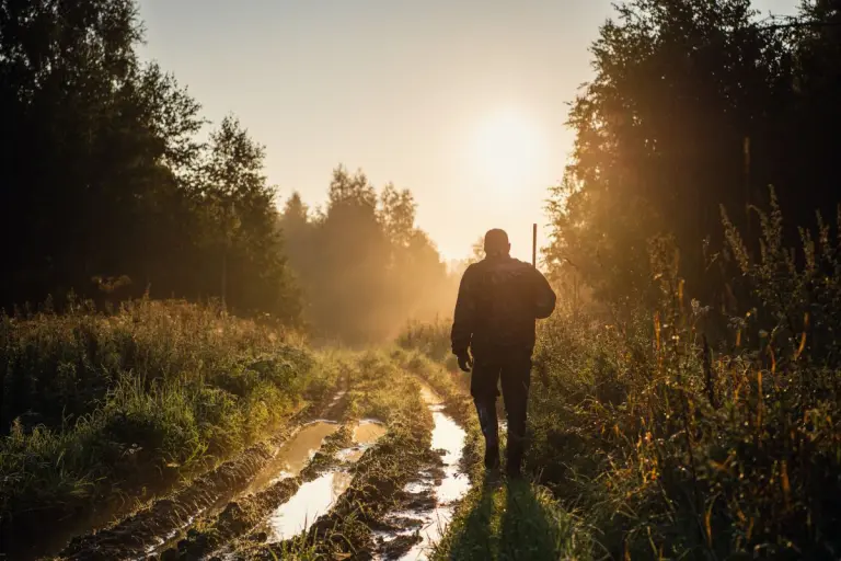 Silhouetted of a hunter with shotgun at beautiful sunset