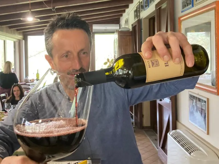 Daniele Ricci mentre serve vino all'interno del suo agriturismo