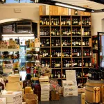 Scaffali dell'Enoteca Del Gatto ad Anzio con una vasta selezione di bottiglie di vino.