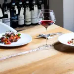 Sala di Magazzino 52 a Torino con tavoli circondati da scaffali che ospitano oltre 1200 vini
