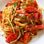 Piatto di spaghetti freddi con pomodoro ed erbe aromatiche