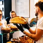 Massimo Ingegni nel laboratorio di Ingrano Forno Artigianale con una pagnotta di pane appena sfornata