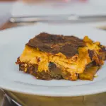 Porzione di moussaka greca con strati di melanzane, ragù e besciamella
