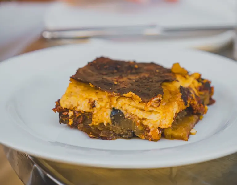 Porzione di moussaka greca con strati di melanzane, ragù e besciamella