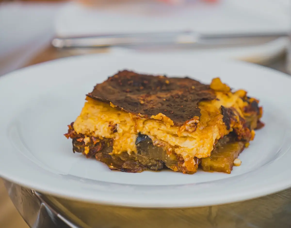 Porzione di moussaka greca con strati di melanzane, ragù e besciamella
