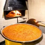 Farinata ligure dorata appena sfornata nel forno a legna dell’Osteria Mattana