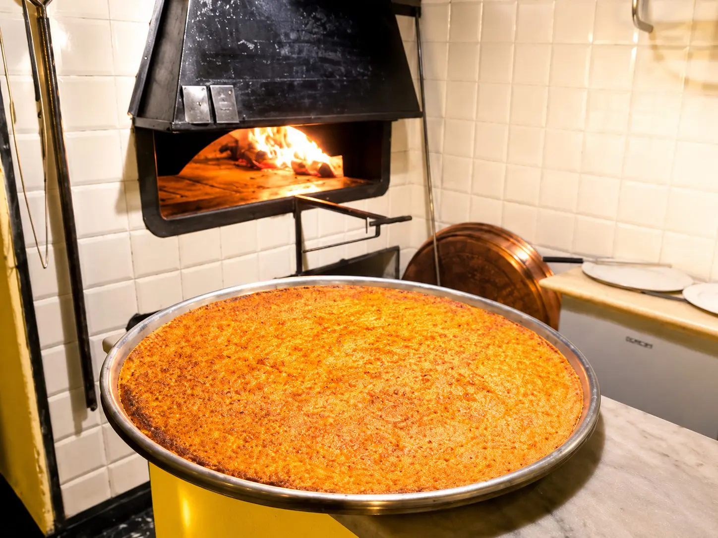 Farinata ligure dorata appena sfornata nel forno a legna dell’Osteria Mattana